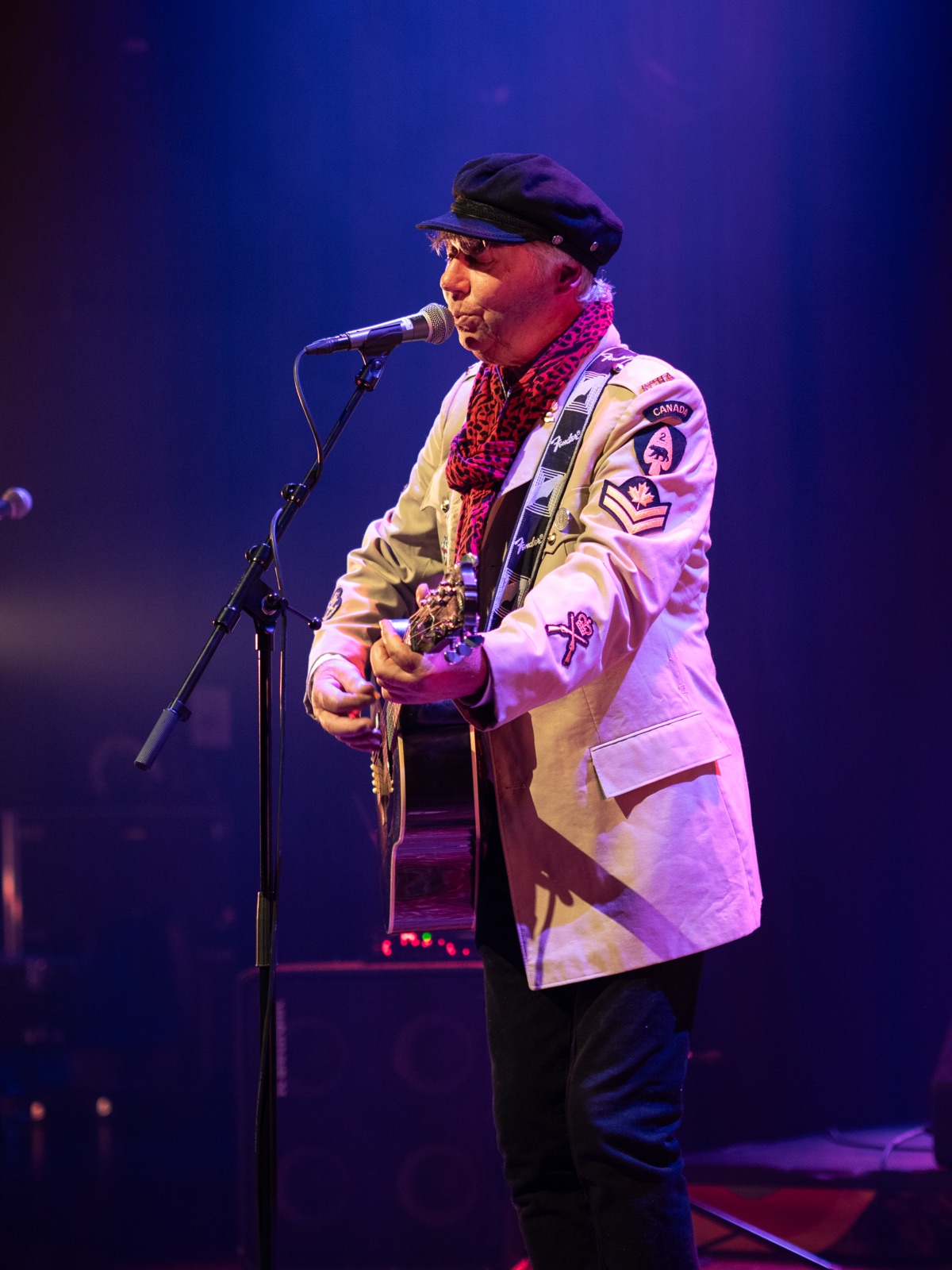 Tor Henning Olsen singing and playing guitar in purple stage light
