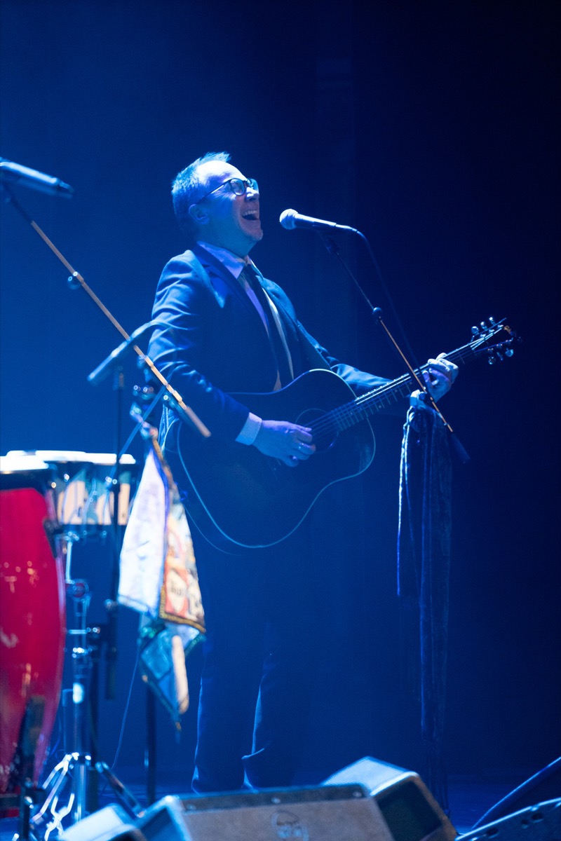 Tor Henning Olsen singing and playing guitar in blue stage light